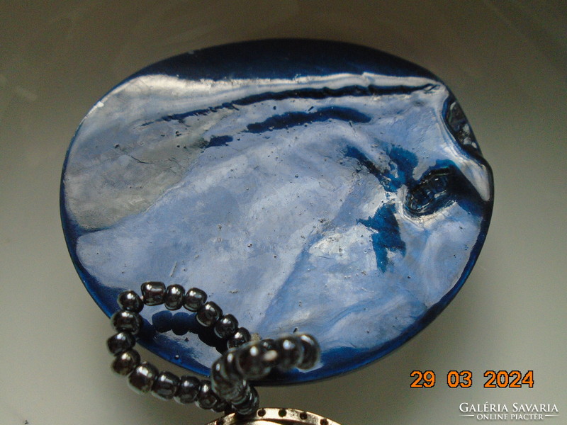Kagyló és ezüstözött kelta medál összefűzve,apró fémes kék gyöngy akasztóval