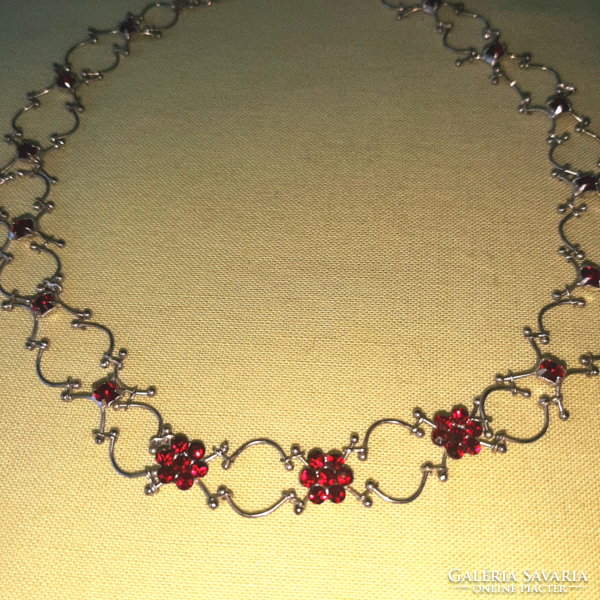 On a silver background, ruby red stone necklace, neck strap