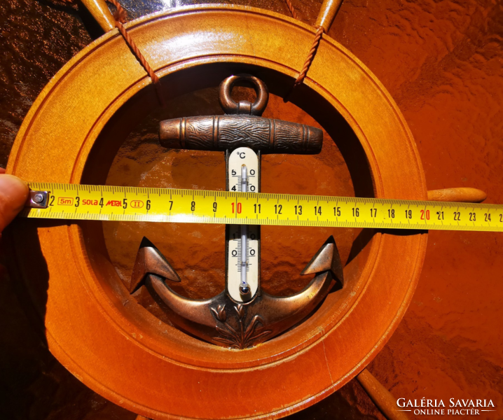 A wooden thermometer in the shape of a ship's rudder