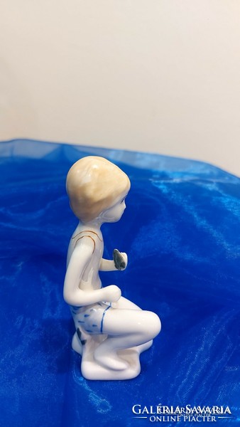 Porcelán térdelő fiú figura.
