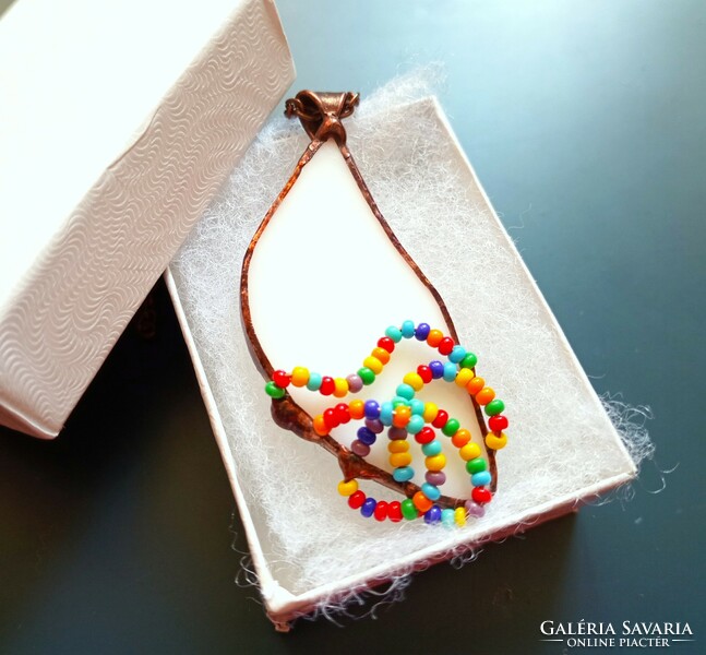 Handmade glass jewelry, waves of colored pearls on white glass