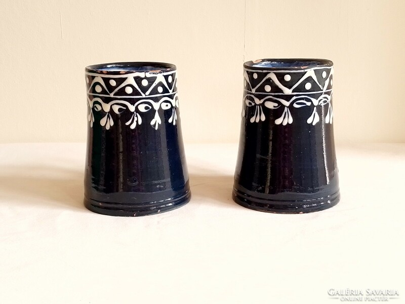 Two ceramic pitcher mugs with a white pattern on an old cobalt blue glazed base