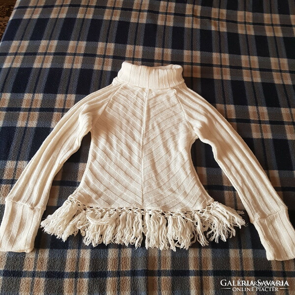 White turtleneck knitted sweater with fringe on the hem and m