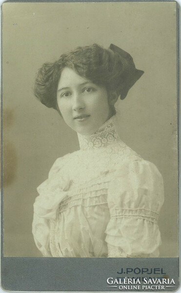 J. Popjel photo studio, Vienna. Portrait of a young, elegant lady with a bow hairdo and a dress with a lace neck.