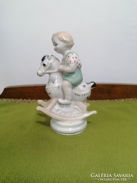 Zhk Russian porcelain toddler with a rocking horse, the horse's ears are damaged
