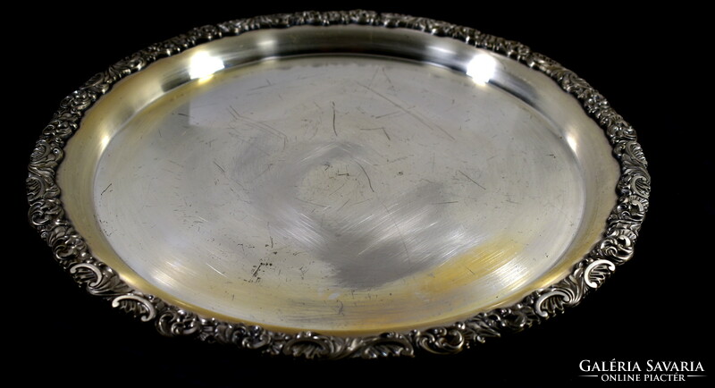 A large round tray silver-plated with a rich relief pattern