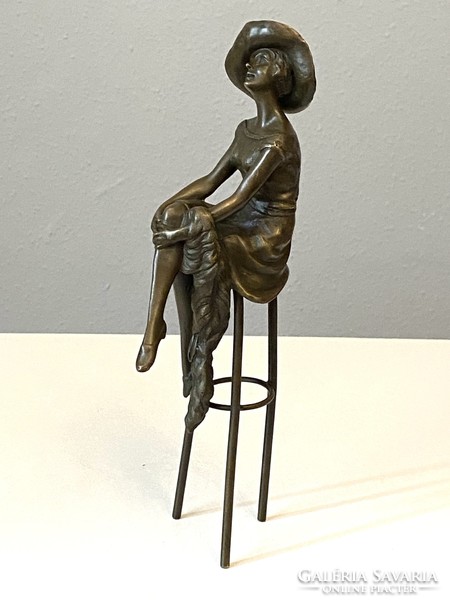 D.H. Chipaus replica bronze statue of a woman in a hat sitting on a bar stool