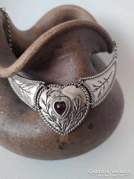 Antique effect silver necklace in a heart socket with burgundy crystal