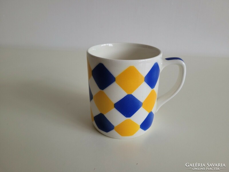 Old granite mug with a blue and yellow checkered pattern