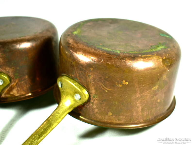 A set of small sauce-making pots with brass handles and red copper