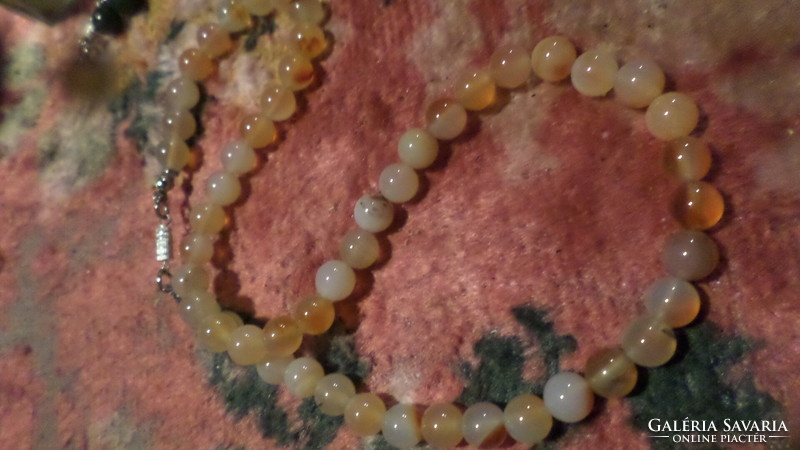 49 cm necklace made of slightly brownish-pink mineral pearls, in good condition.