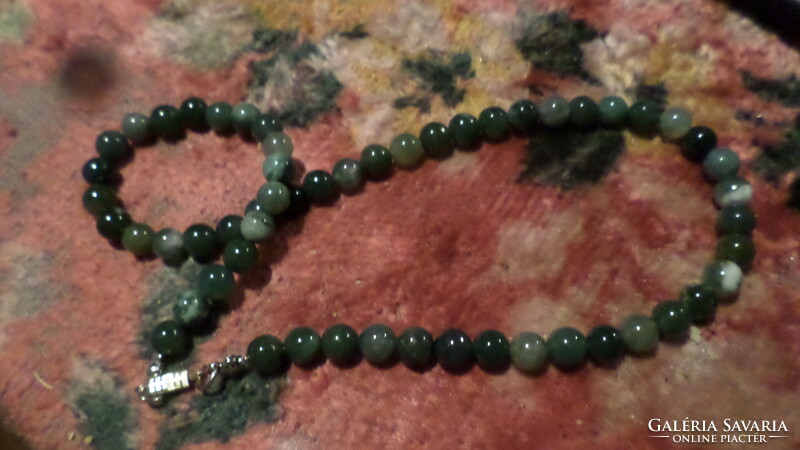 50 cm necklace made of green mineral pearls, in good condition.