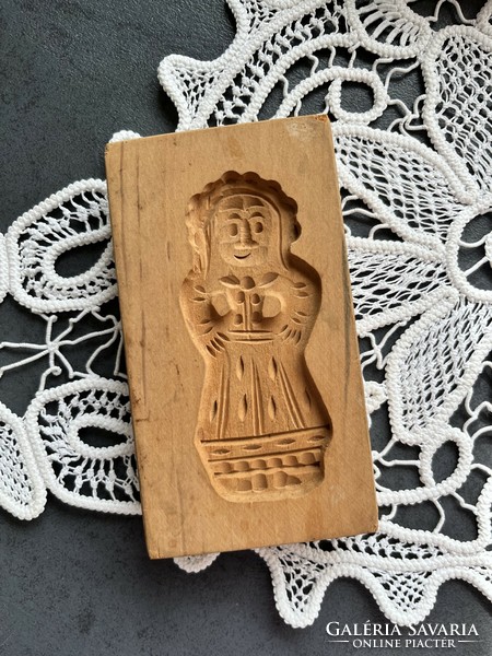 A traditional wooden gingerbread cookie cutter in the shape of a honey doll