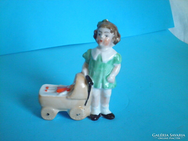 Old German porcelain figurine of a little girl with a pram