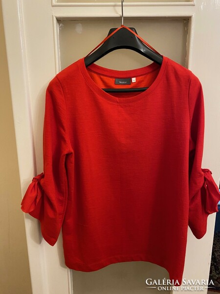 Red, soft, cotton, long-sleeved blouse. With a big bow on the sleeve. I bought it in Austria. Yessica c&a m