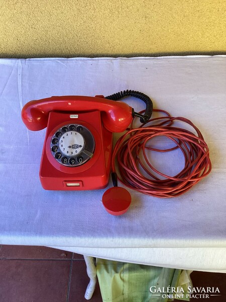 Régi működő piros tárcsás telefon.