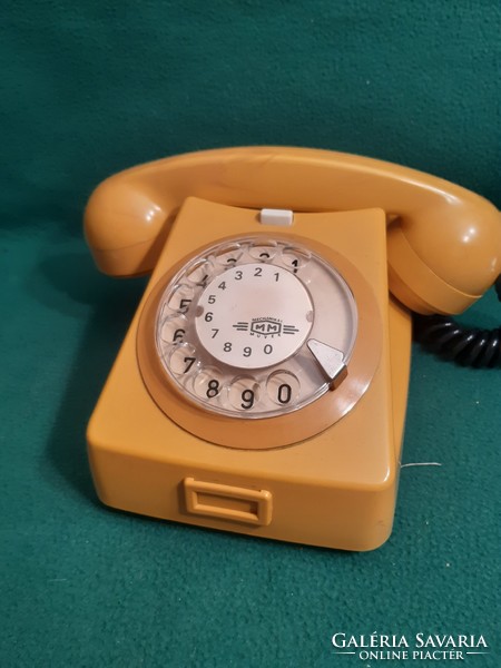 Retro sárga színű tárcsás telefon.