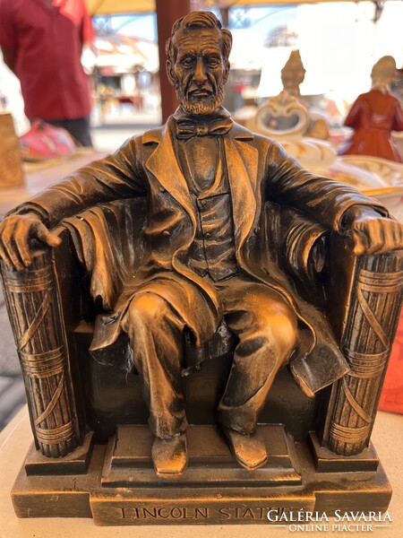 Abraham Lincolnot ábrázoló, bronz hatású kisoromzatú vagy szobor-replikát mutat, amely a washingtoni